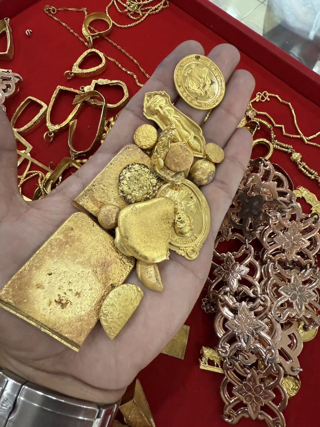 ทองรูปพรรณ ทองเก่า และทองหลอมที่รับซื้อ วางบนถาดกำมะหยี่ของร้าน